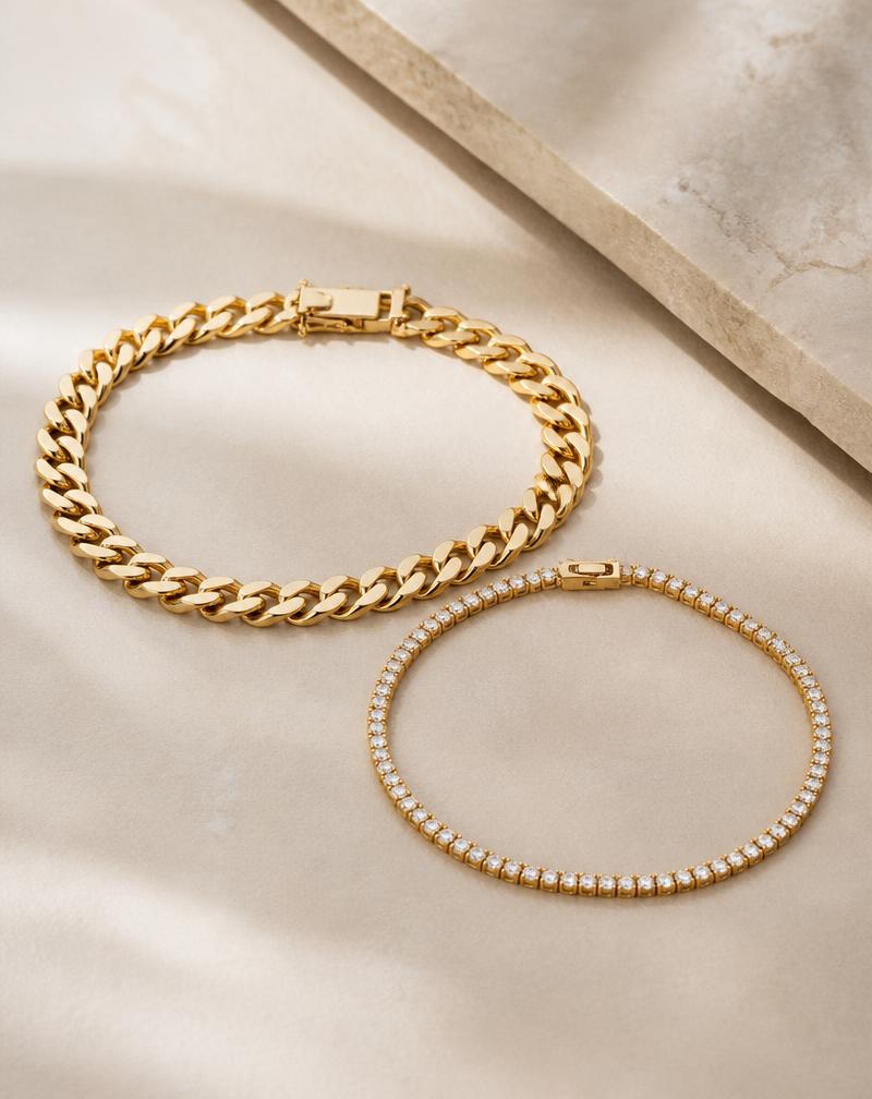 Solid 10K gold cuban link and tennis bracelets on a cream background