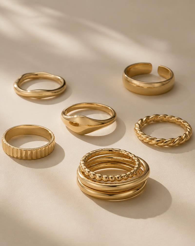 Solid 10K gold rings and stacked bands on a cream background