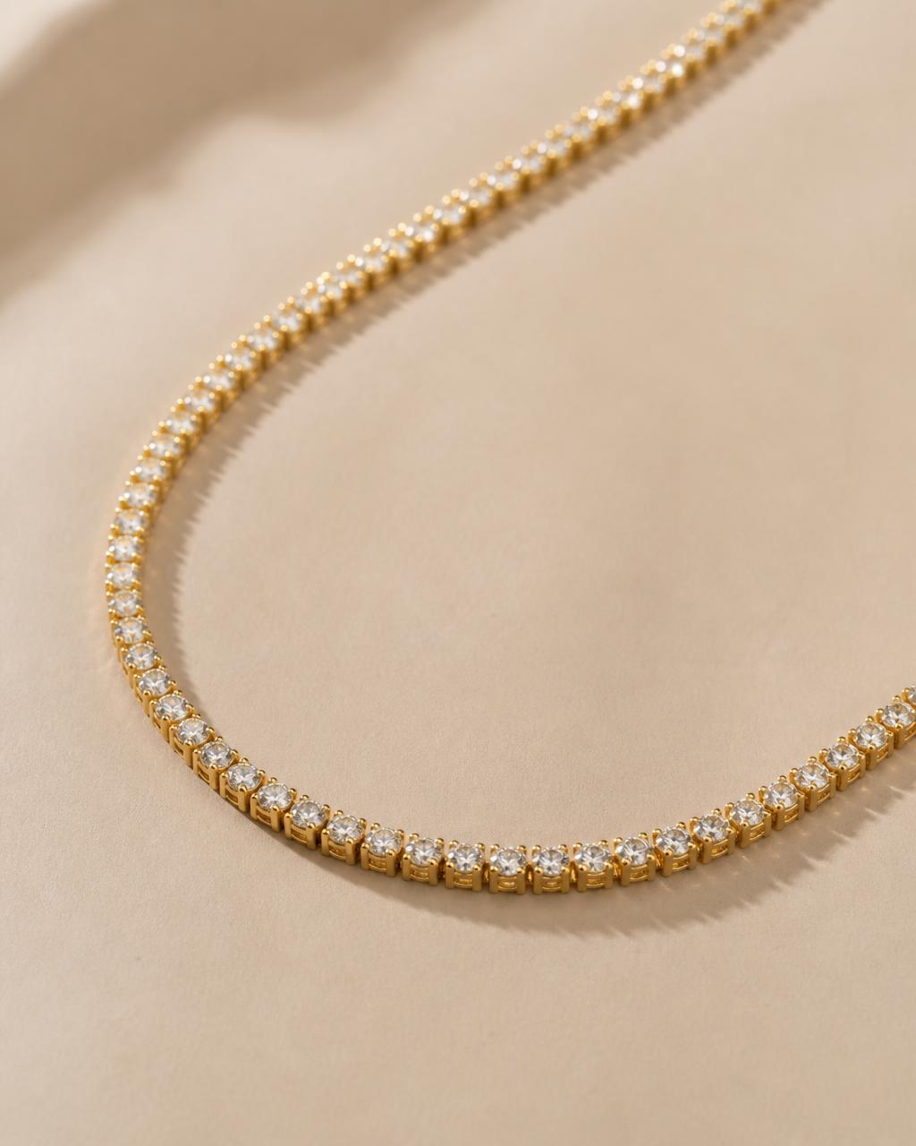 Solid gold tennis chain with clear stones on dark stone